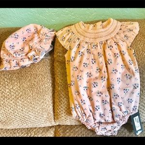 Baby girl onesie outfit with matching hat.